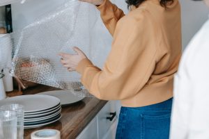 girl packing dishes for moving